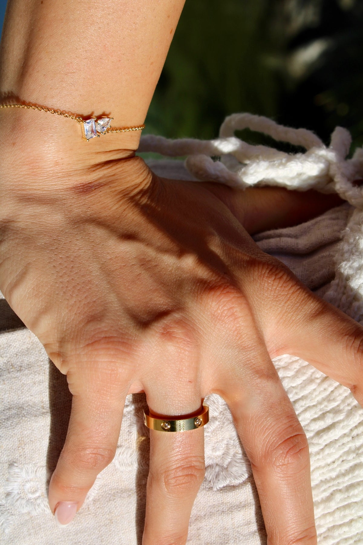 Carson ring worn on a hand in sunlight, styled with the Double Stone Bracelet.