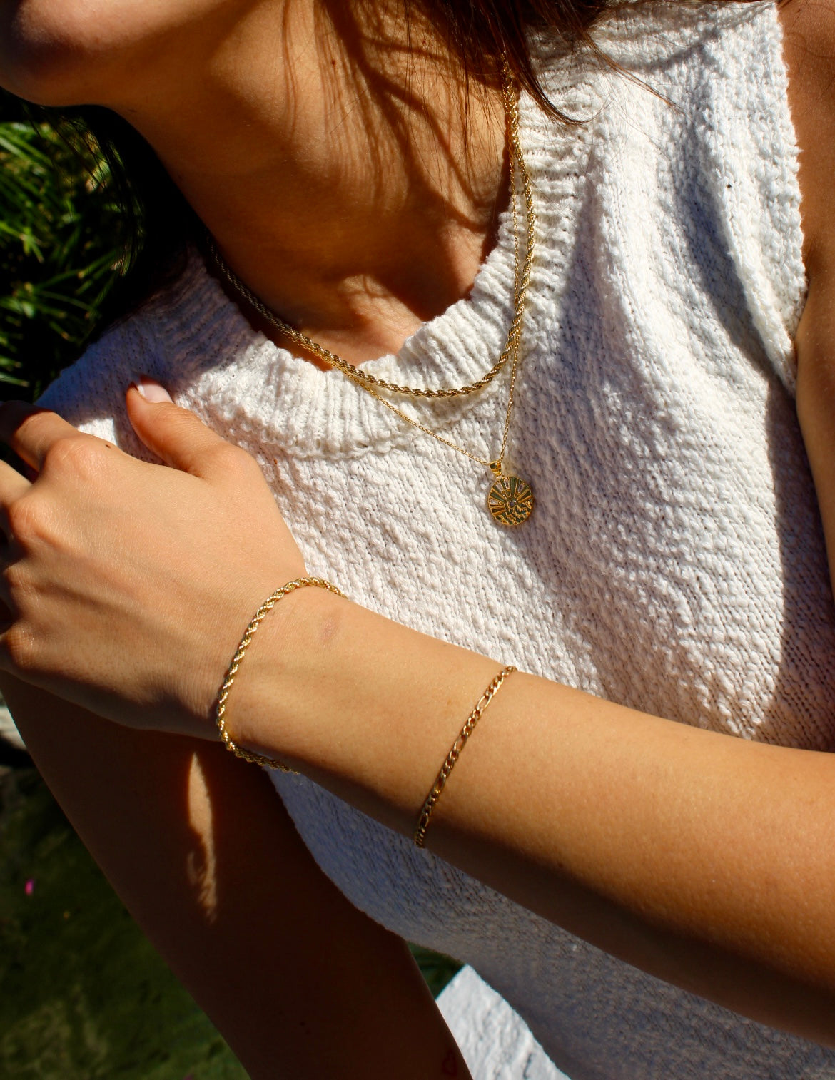 Grayson Rope Bracelet worn beside another chain bracelet, with layered gold necklaces and a white knit top.