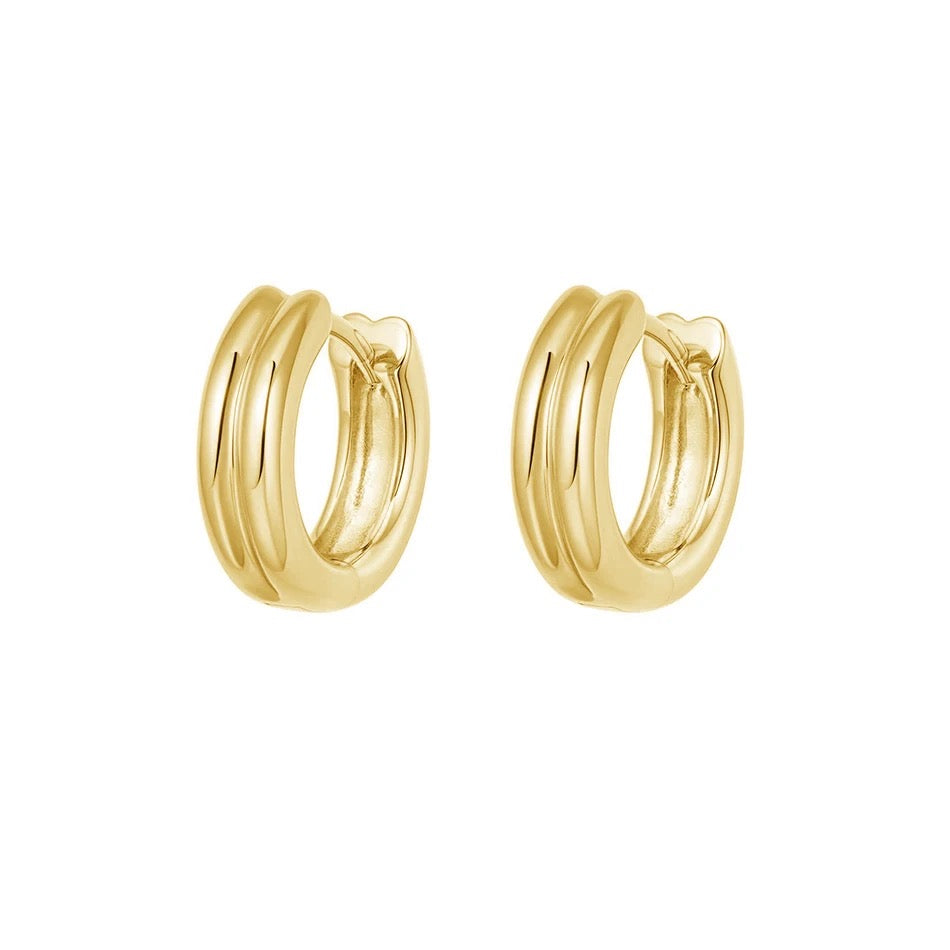 Savannah gold-plated huggie earrings with smooth double-band hoops and hinged closures, shown at an angle on white.