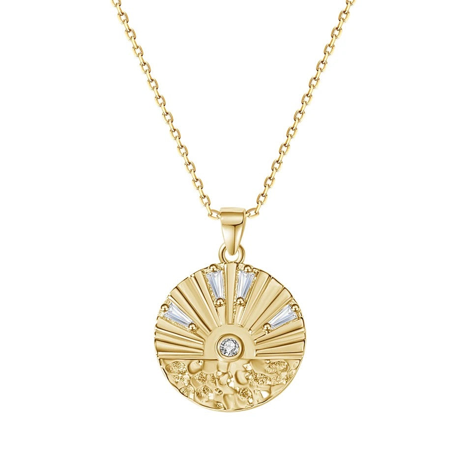 Sunrise Coin Necklace with a round gold-plated pendant featuring radiating engraved lines and clear cubic zirconia accents.
